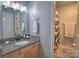 Well-lit bathroom featuring granite countertop, wood cabinets, and a shower with modern fixtures at 5995 Tall Tree Ln, Harrisburg, NC 28075