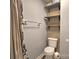 Efficient bathroom with open shelving and a well-maintained toilet area for practical storage and functionality at 5995 Tall Tree Ln, Harrisburg, NC 28075