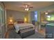 Cozy main bedroom boasts a plush rug, ceiling fan, and an adjacent bathroom for added convenience at 5995 Tall Tree Ln, Harrisburg, NC 28075
