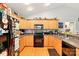 Functional kitchen featuring wood cabinets, black appliances, and laminate countertops at 605 Beavers Cove Nw Ln # 15, Concord, NC 28027