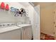 Bright laundry room with washer, dryer, storage shelves, and an open doorway at 605 Beavers Cove Nw Ln # 15, Concord, NC 28027