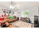 Bright playroom featuring a ceiling fan, a window, and plush sofas at 605 Beavers Cove Nw Ln # 15, Concord, NC 28027