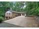 An exterior view of the front of the house, showing the long driveway and surrounding trees at 6227 Dogwood Ln, Waxhaw, NC 28173