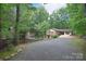 An exterior view of a brick home with carport and long gravel driveway at 6227 Dogwood Ln, Waxhaw, NC 28173