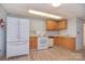 Functional kitchen featuring oak cabinets, white appliances, and modern light wood flooring at 6227 Dogwood Ln, Waxhaw, NC 28173