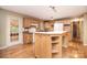 Bright kitchen featuring wood cabinetry, laminate counters, an island with built-in storage, and hardwood floors at 6227 Dogwood Ln, Waxhaw, NC 28173