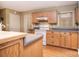 Well-lit kitchen boasting wood cabinets, laminate counters, hardwood floors, and white appliances, offering a welcoming atmosphere at 6227 Dogwood Ln, Waxhaw, NC 28173