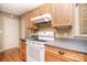 Functional kitchen featuring wood cabinets, laminate counters, a white oven, and hardwood floors, perfect for everyday cooking at 6227 Dogwood Ln, Waxhaw, NC 28173