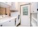 Functional laundry room featuring white appliances, brick accents, and ample storage space at 6227 Dogwood Ln, Waxhaw, NC 28173