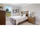 Cozy bedroom with wood furniture, plush bedding, and a large window overlooking the backyard at 7137 Butternut Oak Ter, Huntersville, NC 28078