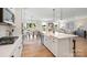 Modern open-concept kitchen featuring stainless steel appliances, large island, and hardwood floors at 7137 Butternut Oak Ter, Huntersville, NC 28078