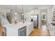 Bright kitchen featuring a large island with a sink, stainless steel appliances, and hardwood flooring at 7137 Butternut Oak Ter, Huntersville, NC 28078