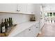 Elegant kitchen with white cabinetry, quartz countertops, wine rack, and herringbone backsplash at 7137 Butternut Oak Ter, Huntersville, NC 28078