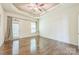 Spacious bedroom with hardwood floors, a tray ceiling, and access to the backyard at 8336 Early Bird Way, Mint Hill, NC 28227