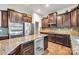 Kitchen with stainless steel appliances, granite countertops, wine fridge, and brown cabinetry at 8336 Early Bird Way, Mint Hill, NC 28227