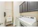 Functional laundry room includes washer, dryer, utility sink and storage cabinets at 8336 Early Bird Way, Mint Hill, NC 28227