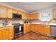 Updated kitchen with stainless steel appliances, wood cabinets, and mosaic backsplash at 8511 Redding Glen Ave, Charlotte, NC 28216