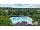 Aerial view of community pool with lounge chairs and mature trees surrounding the pool area at 8511 Redding Glen Ave, Charlotte, NC 28216