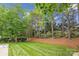 Lush backyard features manicured lawn, mature trees, and landscaping creating a serene and private outdoor space at 8612 Tintinhull Ln, Waxhaw, NC 28173