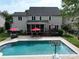 A backyard featuring a well-maintained pool, a covered patio, an outdoor dining set, and a grill at 8612 Tintinhull Ln, Waxhaw, NC 28173