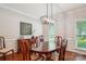 Elegant dining room with wood floors, a large table, chandelier, wainscoting, and ample natural light at 8612 Tintinhull Ln, Waxhaw, NC 28173
