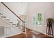 A spacious entryway with hardwood floors and a staircase featuring white risers and wood railing at 8612 Tintinhull Ln, Waxhaw, NC 28173