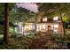 Expansive backyard with mature trees, screened porch, patio, and lush landscaping creating a private retreat at 8700 Thornbury Ln, Huntersville, NC 28078