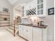 Dry bar with white cabinetry, granite countertop, wine rack, and storage space at 8700 Thornbury Ln, Huntersville, NC 28078