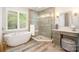Spa-like bathroom featuring a freestanding tub, a glass enclosed shower, and a makeup vanity providing ultimate relaxation at 8700 Thornbury Ln, Huntersville, NC 28078
