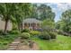 Traditional brick home with lush landscaping, black shutters, and stone steps leading to the entrance at 8700 Thornbury Ln, Huntersville, NC 28078