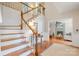 Inviting foyer with wood floors, staircase, and a glimpse of the living room fireplace at 8700 Thornbury Ln, Huntersville, NC 28078
