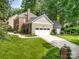 Well-maintained front yard featuring lush lawn, landscaped walkway, and a spacious driveway at 8700 Thornbury Ln, Huntersville, NC 28078