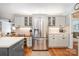 Kitchen with stainless steel refrigerator, custom cabinets, and hardwood floors at 8700 Thornbury Ln, Huntersville, NC 28078