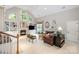 Bright living room with a fireplace, built-in shelves, large windows, and vaulted ceilings at 8700 Thornbury Ln, Huntersville, NC 28078