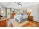Relaxing main bedroom features a ceiling fan, tray ceiling, and hardwood floors creating an inviting space to unwind at 8700 Thornbury Ln, Huntersville, NC 28078