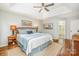 Comfortable main bedroom featuring a ceiling fan, tray ceiling, hardwood floors, and access to the en suite bath at 8700 Thornbury Ln, Huntersville, NC 28078