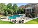 Lush backyard with a beautiful in-ground pool, hot tub, lounge chairs, fire pit and outdoor seating area at 9021 Unbridle Ln, Waxhaw, NC 28173