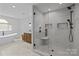 A spa-like primary bathroom features a glass shower, marble tiling, and double vanities at 9021 Unbridle Ln, Waxhaw, NC 28173