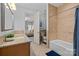 This bathroom is styled with a granite countertop, tub, and tile flooring at 9021 Unbridle Ln, Waxhaw, NC 28173