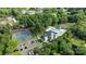Aerial view of a community clubhouse with a swimming pool, tennis courts, and parking area surrounded by lush trees at 9021 Unbridle Ln, Waxhaw, NC 28173