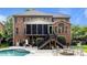 Exterior of a brick home featuring a screened-in porch, backyard pool, and outdoor entertaining area at 9021 Unbridle Ln, Waxhaw, NC 28173