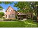 Beautiful brick home featuring lush landscaping, black shutters, and a covered porch, offering classic curb appeal at 9021 Unbridle Ln, Waxhaw, NC 28173