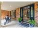 Inviting front porch with rocking chairs, brick siding, and welcome mat leading to the interior staircase at 9021 Unbridle Ln, Waxhaw, NC 28173