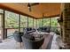 Comfortable screened porch with stone fireplace, ceiling fans and outdoor seating, overlooking a lush backyard landscape at 9021 Unbridle Ln, Waxhaw, NC 28173