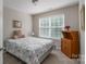 Cozy bedroom with a large window, wooden cabinet, and comfortable bed at 916 Coffee Tree Ln, Rock Hill, SC 29732
