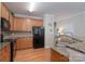 Functional kitchen featuring wood cabinets, black appliances, and a granite counter at 916 Coffee Tree Ln, Rock Hill, SC 29732