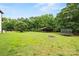 A large backyard with green grass, mature trees, a trampoline, and a fire pit at 930 Hawley Rd, McConnells, SC 29726