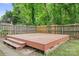 Spacious backyard featuring a level deck area, surrounded by a privacy fence and lush greenery at 9437 Macquarie Ln, Charlotte, NC 28227