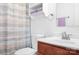 Bathroom with a white sink, cherry wood cabinet, decorative towels and a shower with a curtain at 9437 Macquarie Ln, Charlotte, NC 28227