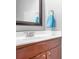 Bathroom vanity with cherry cabinets, white countertop, and a framed mirror at 9437 Macquarie Ln, Charlotte, NC 28227